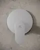 Brausearmatur von Ideal Standard mit runder Rosette und Hebel zur Temperaturregelung, installiert an einer glatten, hellen Wand.